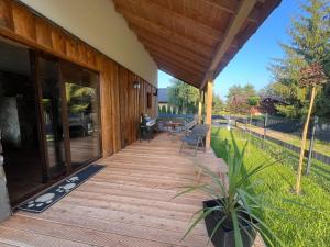 a porch of a house with a wooden deck at Relax Chańcza in Pągowiec