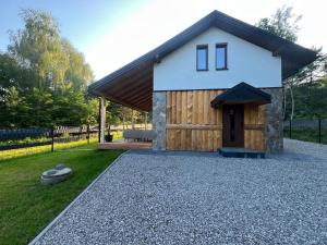 a house with a gambrel roof and a gravel driveway at Relax Chańcza in Pągowiec