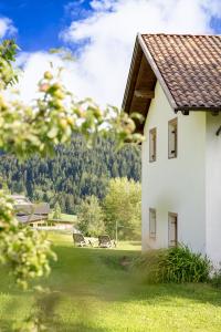 a white building with a yard with two benches at Apartments Schießstand in Avelengo
