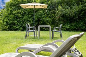 a group of chairs and a table and an umbrella at Apartments Schießstand in Avelengo +18 photos