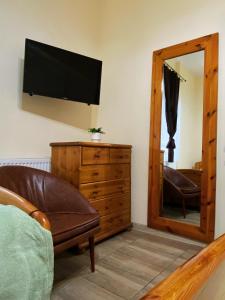 a living room with a couch and a television on the wall at The Stone Garden Apartment - free parking, private yard in Sinaia