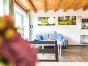 a living room with a blue couch and a table at Ferienhof Häckler in Ochsenhausen