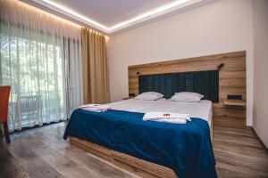 a bedroom with a large bed with a blue blanket at Complex Perpera in Stambolovo +53 photos