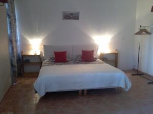a bedroom with a white bed with red pillows at E I PERLES de AIME in Laurac-en-Vivarais