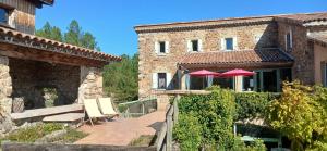 a house with a patio with two umbrellas at E I PERLES de AIME in Laurac-en-Vivarais