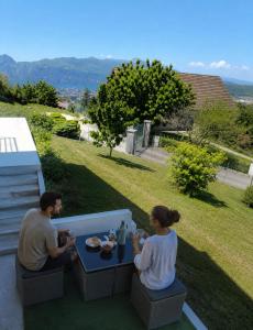 a man and a woman sitting at a table at Appartement indépendant dans maison au calme in Pugny-Chatenod
