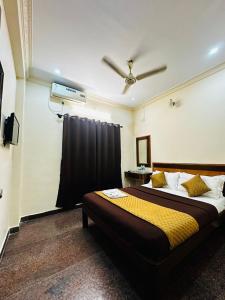 a bedroom with a large bed with a ceiling fan at Sahara Residency Mysore in Mysore +9 photos