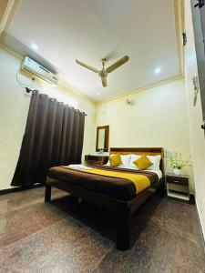 a bedroom with a bed and a ceiling fan at Sahara Residency Mysore in Mysore