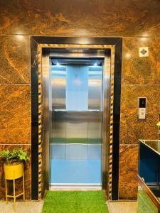 a metal elevator with grass in front of a wall at Sahara Residency Mysore in Mysore