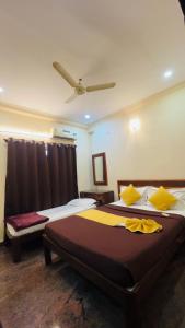 a bedroom with two beds and a ceiling at Sahara Residency Mysore in Mysore