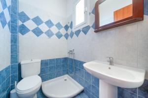a blue and white bathroom with a toilet and a sink at Hotel Smaragdi in Chrysi Ammoudia +35 photos
