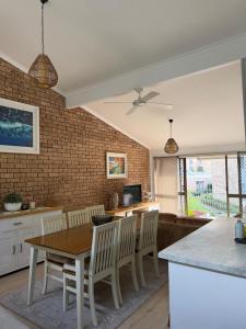 a kitchen and dining room with a table and chairs at Coconuts - 3 bedroom 3 bathroom townhouse with tennis court in Nelson Bay