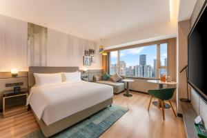 a bedroom with a bed and a living room at Holiday Inn Shanghai Nanjing Road by IHG in Shanghai