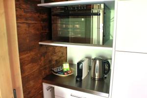 a kitchen counter with a coffee maker and a microwave at BergZeit- Relax Explore Belong in Stalden