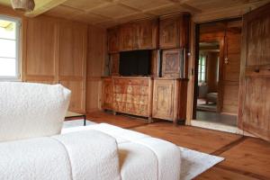 a living room with a couch and a tv at BergZeit- Relax Explore Belong in Stalden
