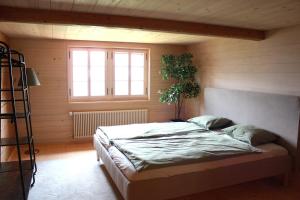 a bedroom with a bed and a plant in it at BergZeit- Relax Explore Belong in Stalden