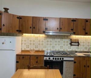 a kitchen with a stove and a wooden table at Alba Holiday in Vallecorsa