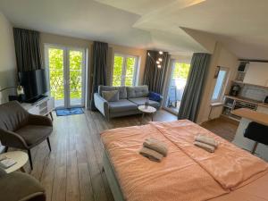 a bedroom with a large bed and a living room at Eicher Ferienwohnungen Warnemünde in Warnemünde