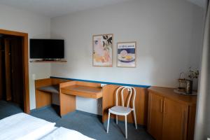 a bedroom with a desk and a bed and a chair at Gasthof Thünauer in Offenhausen +30 photos