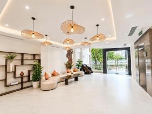 a large lobby with couches and tables and potted plants at LAVISH OCEAN INN Đà Nẵng in Danang