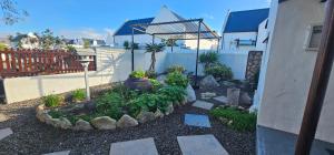 a garden with plants in a yard next to a house at Harts Water in Jacobs Bay