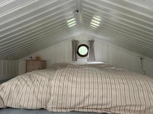 a bed in a white room with a window at 'Ekhaga Cabins' Lillestugan in Viddviken