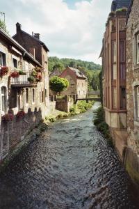a river between two buildings in a town at Hotel Burghof in Stolberg +7 photos