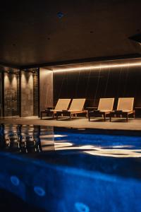 a swimming pool with chairs and a swimming pool at Serras Andorra in Soldeu
