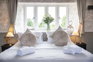 a white bed with white pillows and a window at The Lighthouse Bed & Breakfast in Frome