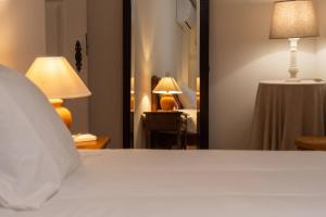 a bedroom with a bed and a table with a lamp at Casa do Muro Alto in Alvelos +40 photos