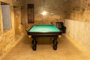 a pool table in a stone room with a door at Casa do Muro Alto in Alvelos