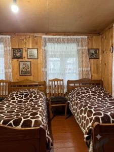 a bedroom with two beds and a window at Guest House Nazo in Omalo