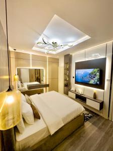 a bedroom with a large bed and a flat screen tv at Luxury 2BR Oasis in Lekki