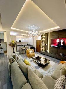 a large living room with a couch and a tv at Luxury 2BR Oasis in Lekki
