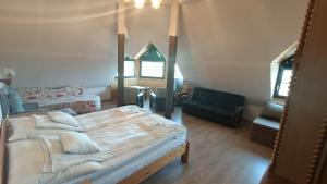 a bedroom with a large bed and a chair at Nagy Vendégház in Badacsonytomaj