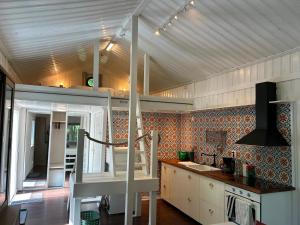 a kitchen with white cabinets and a staircase in it at 'Ekhaga Cabins' Lillestugan in Viddviken +25 photos