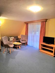 a living room with two chairs and a television at Bäuerlehof in Seebach