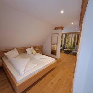a bedroom with a bed with white sheets and a mirror at Bäuerlehof in Seebach