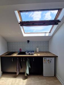 a kitchen with a skylight in the ceiling at Super Mario Studio ! in Jaunay-Clan +6 photos