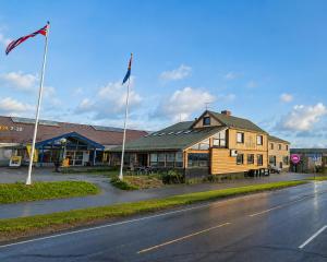 a building on the side of a street with a flag at 8 Seasons Hotel in Varangerbotn
