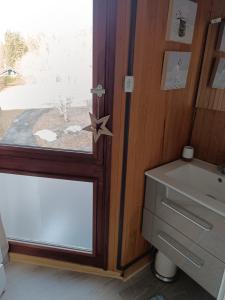 a glass door with a star next to a sink at Bel Appartement panoramique in Arâches-la-Frasse