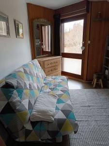 a living room with a couch and a window at Bel Appartement panoramique in Arâches-la-Frasse