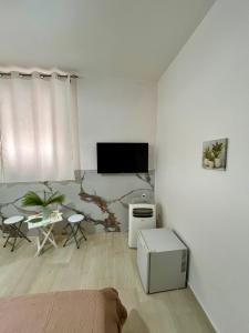 a white living room with a tv and a couch at B&B Tribale in Ercolano