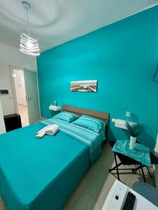 a blue bedroom with a bed and a desk at B&B Tribale in Ercolano