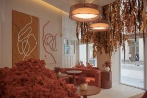 a lobby with a couch and tables and flowers at SLEEP'N Valencia in Valencia