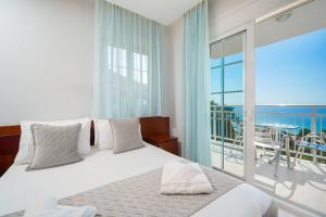 a bedroom with a bed with a view of the ocean at Hotel Smaragdi in Chrysi Ammoudia