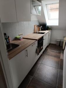 a kitchen with white cabinets and a sink and a window at Manjana`s Waldblick in Braunlage
