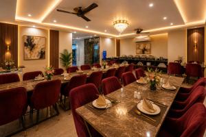 a conference room with long tables and red chairs at Sunburry Hotel Tapovan Rishikesh in Narendranagar