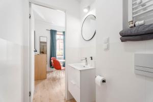 a white bathroom with a sink and a mirror at Enjoy! Piaseczno in Piaseczno