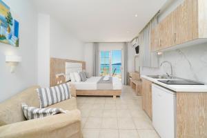 a kitchen and a living room with a bed and a couch at Hotel Smaragdi in Chrysi Ammoudia